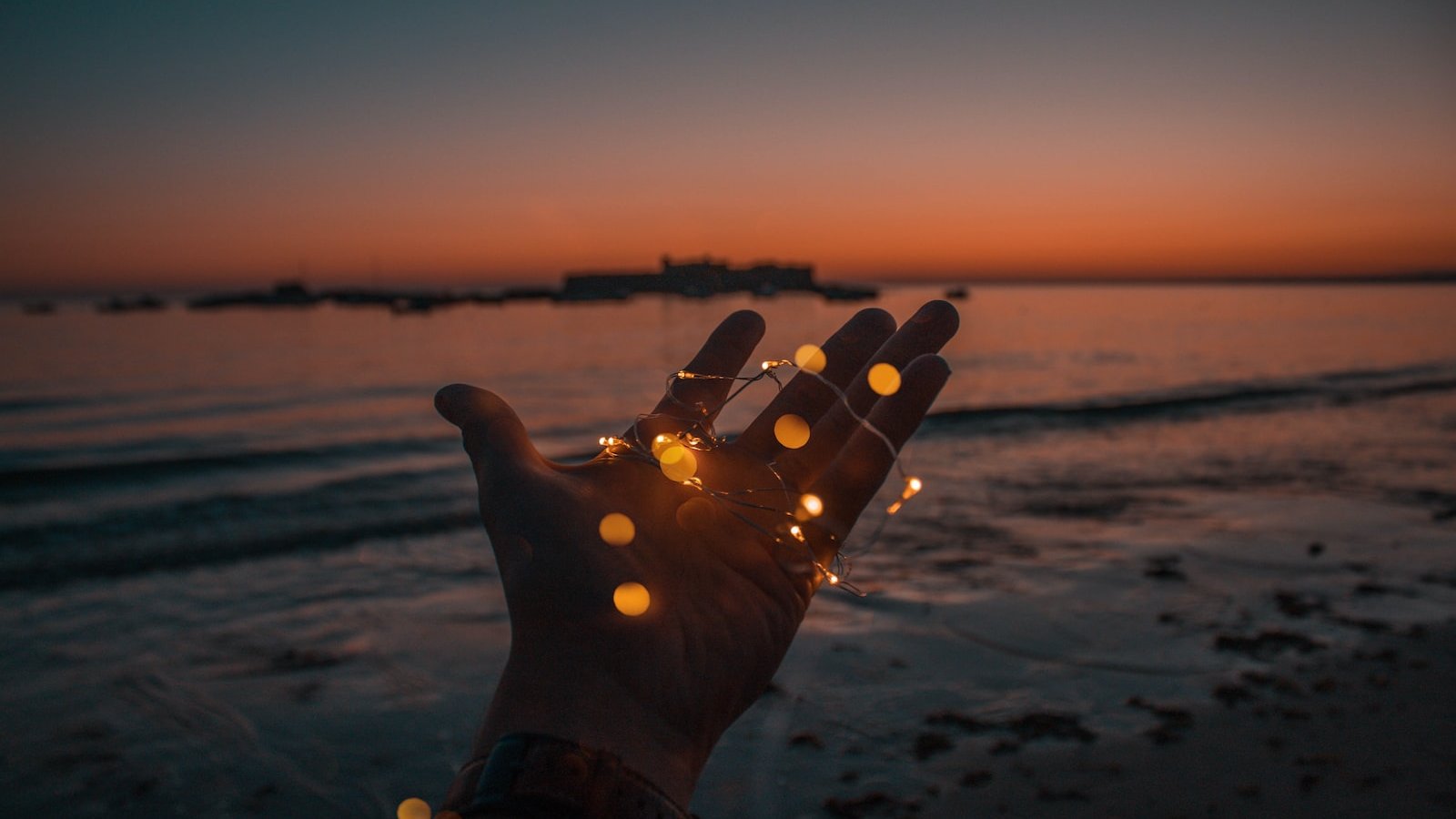 person with string lights on left hand