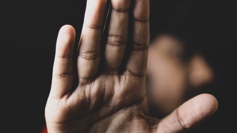 persons left hand on black background