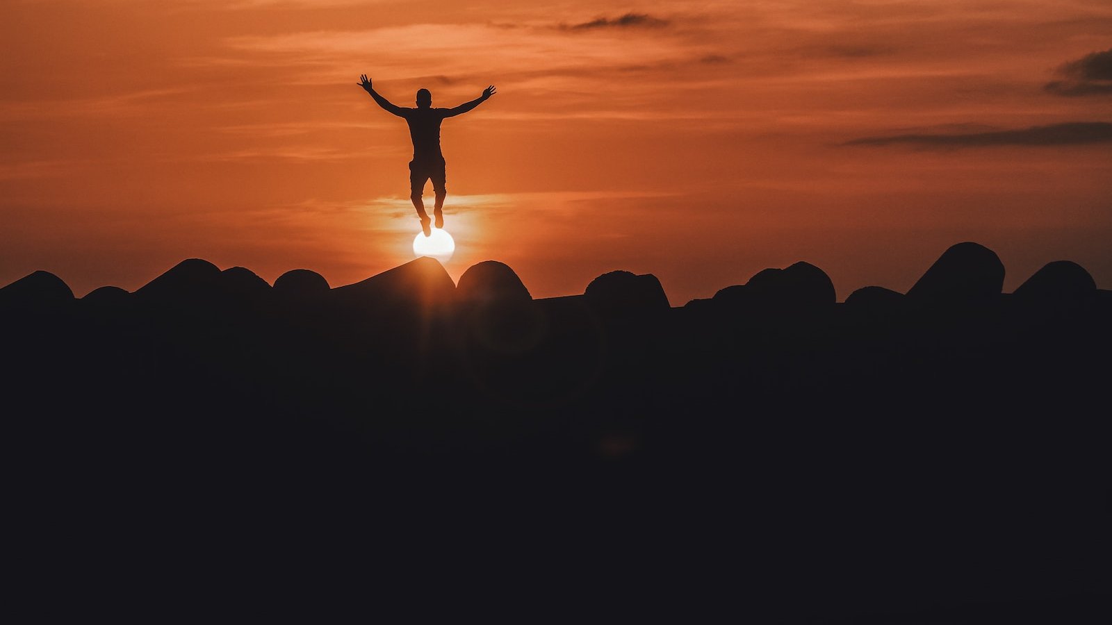 silhouette of person jumping in mid air