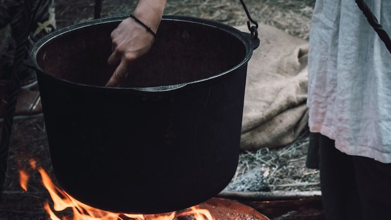 woman cooking on black metal cooking pot