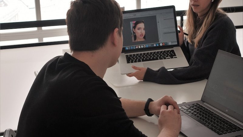 man in black long sleeve shirt using macbook pro