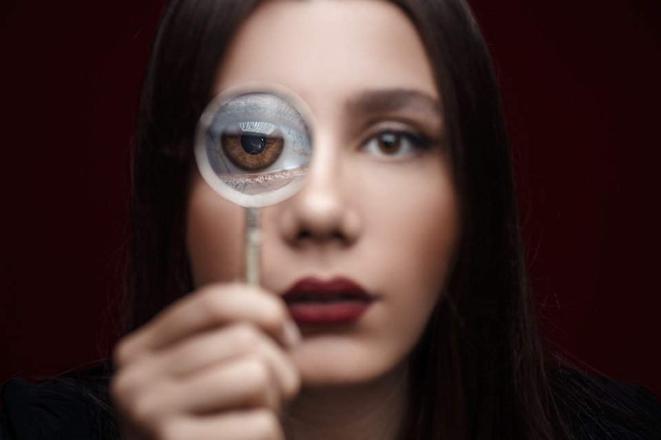 woman looking through magnifying glass