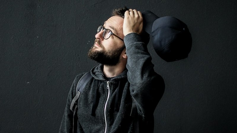 man looking up holding his hair
