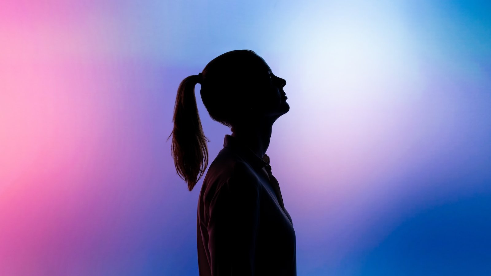 silhouette of woman wearing black hat and black coat