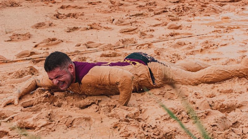 boy in red and blue shirt lying on brown sand during daytime