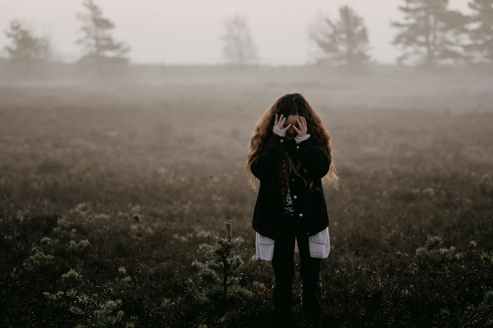 woman in black jacket standing on grass field