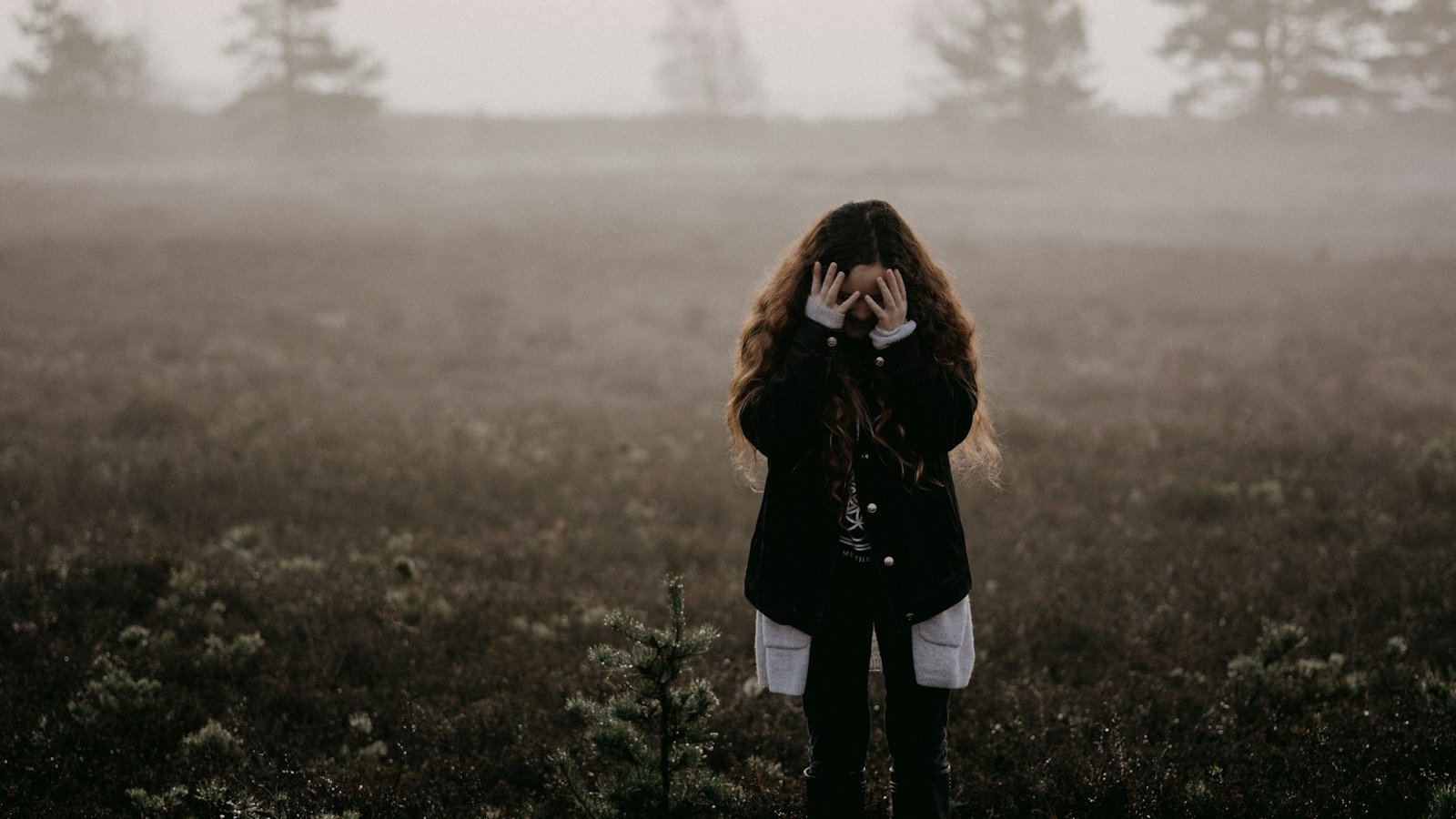 woman in black jacket standing on grass field