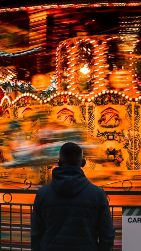 a man standing in front of a carnival ride