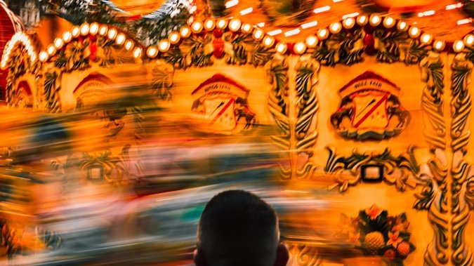 a man standing in front of a carnival ride