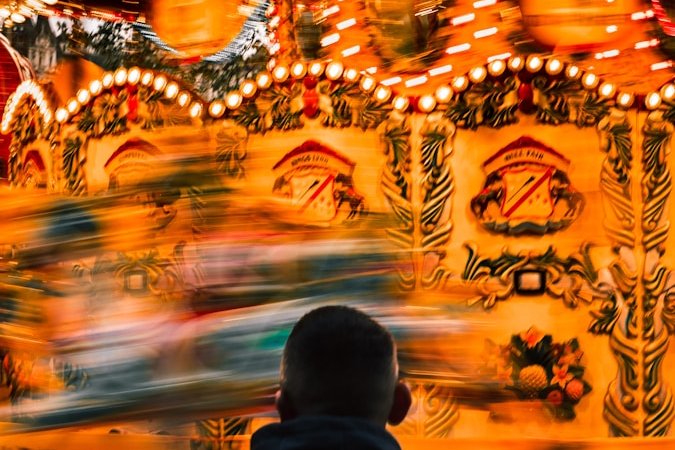 a man standing in front of a carnival ride