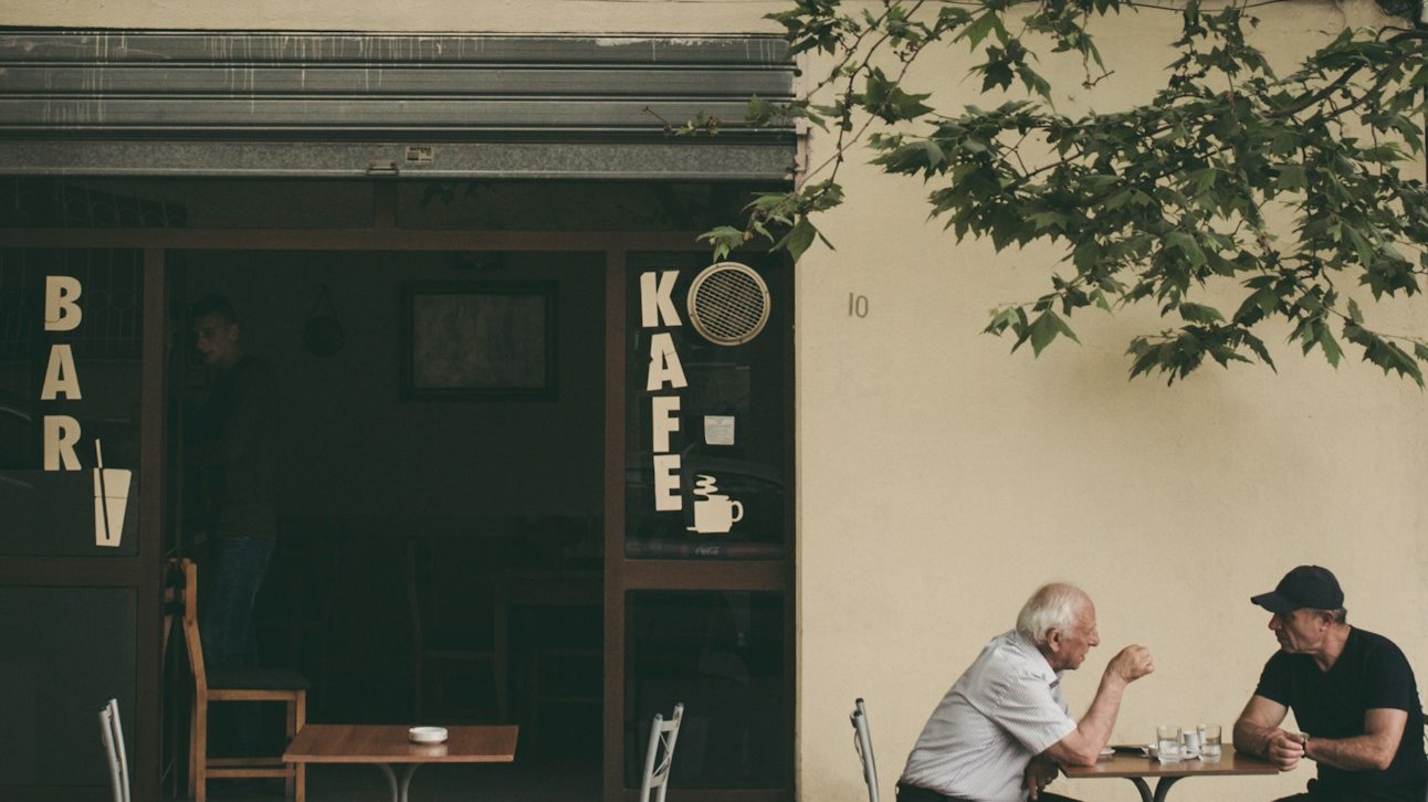 two man chatting white sitting on brown wooden chair