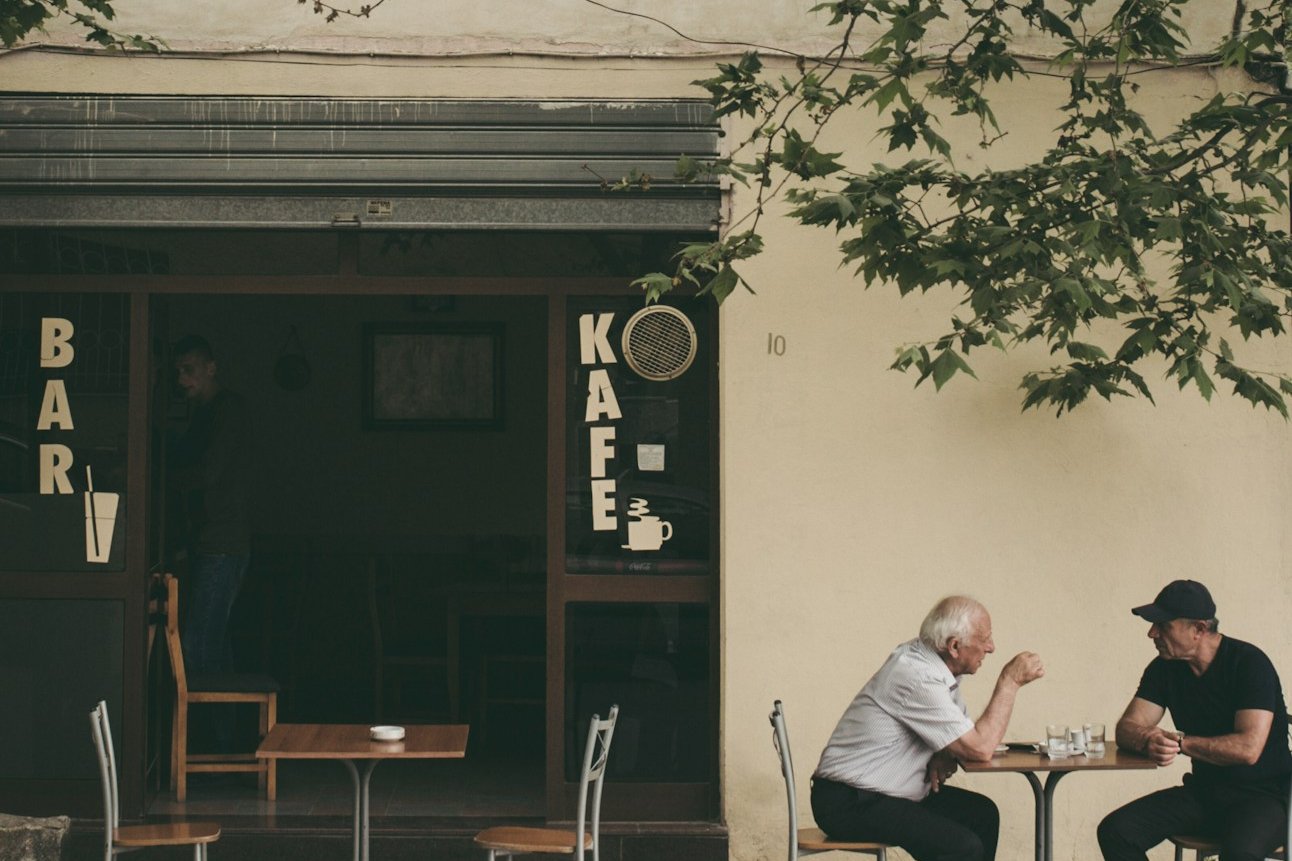 two man chatting white sitting on brown wooden chair