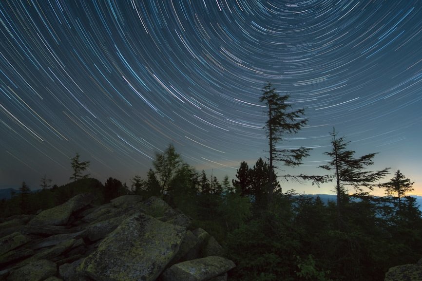the night sky with a star trail in the background