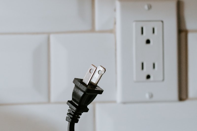 black usb cable plugged in white electric socket