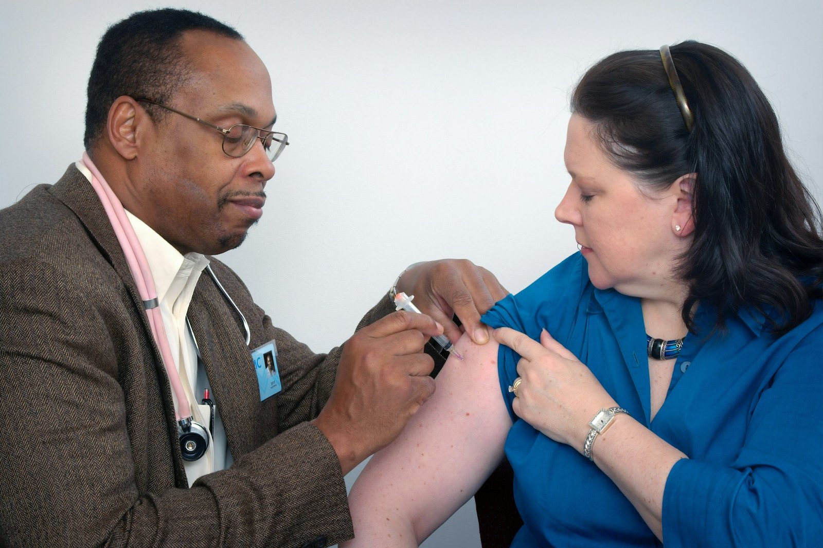 man inject woman on right arm