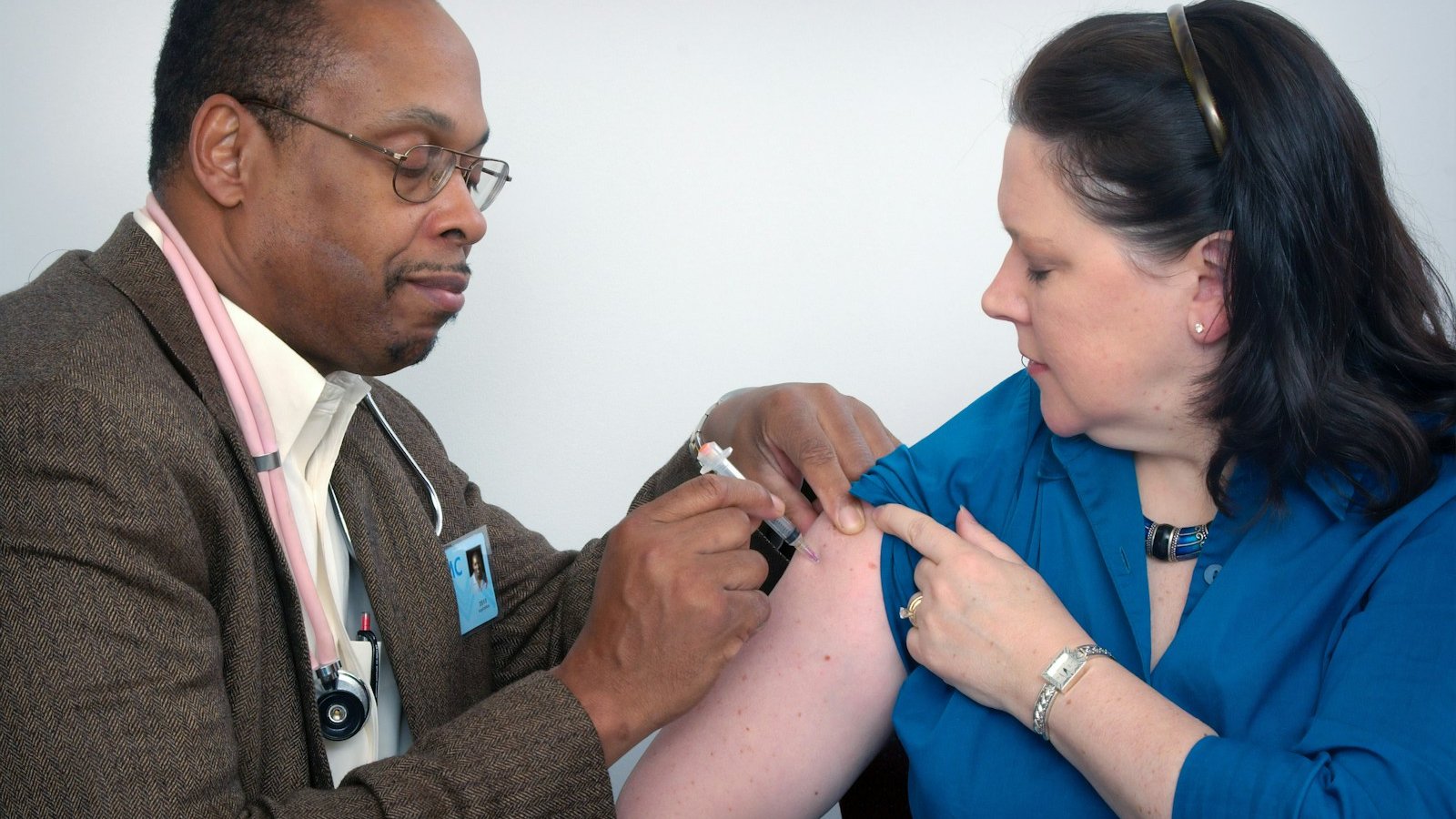 man inject woman on right arm