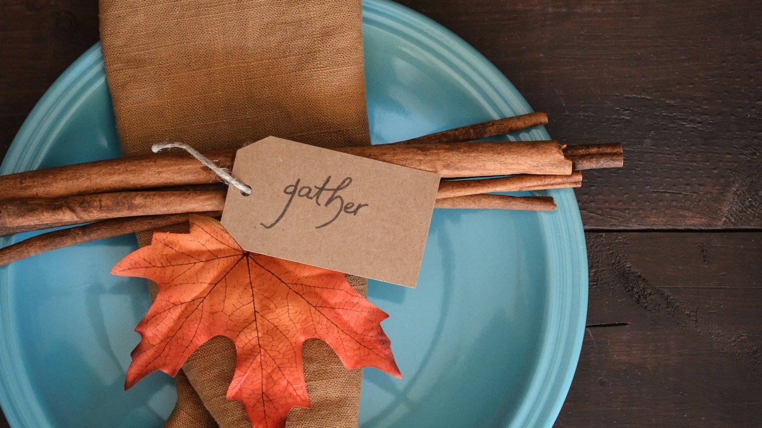 a blue plate topped with an orange and brown leaf