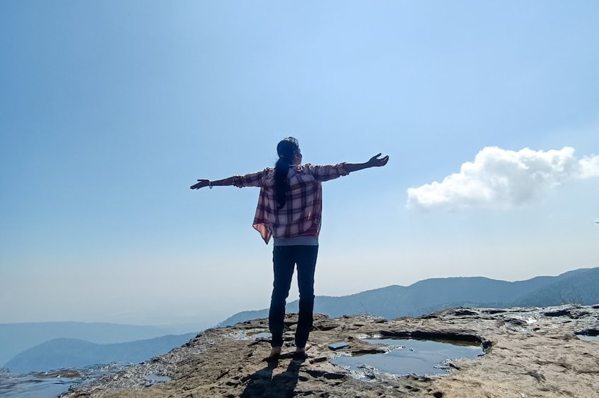 a person standing on a rocky beach