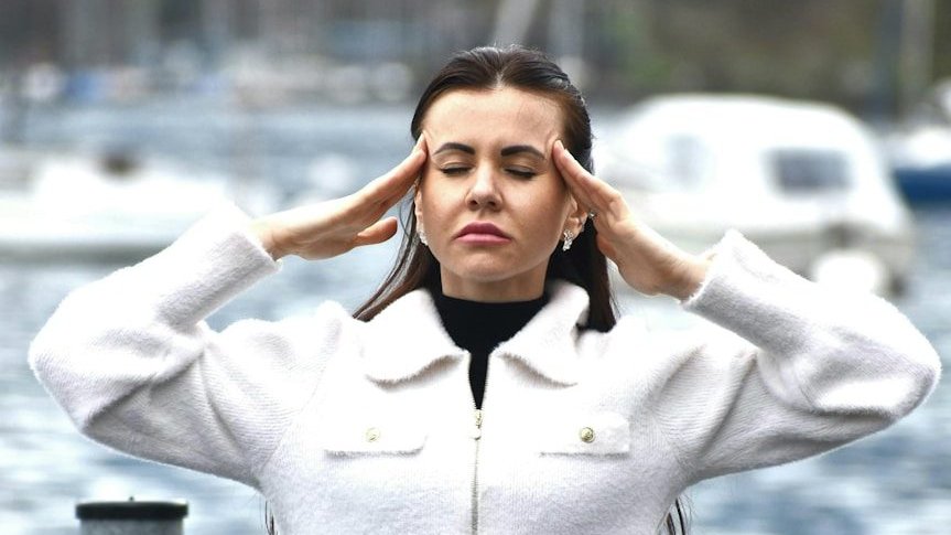 A woman in a white jacket and black skirt