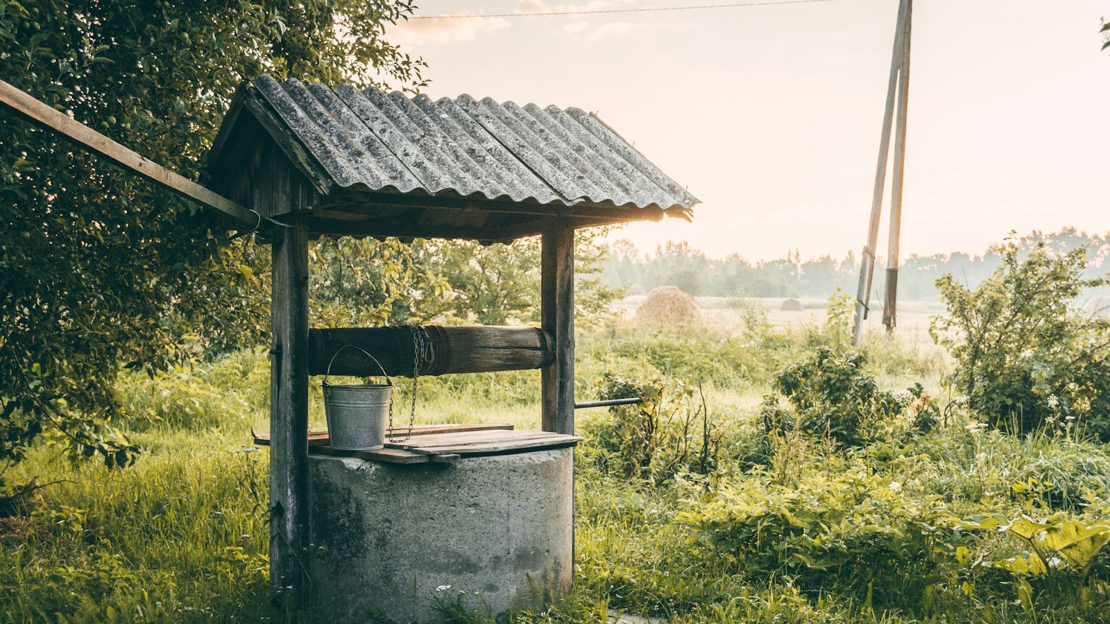 a well in the middle of a grassy field