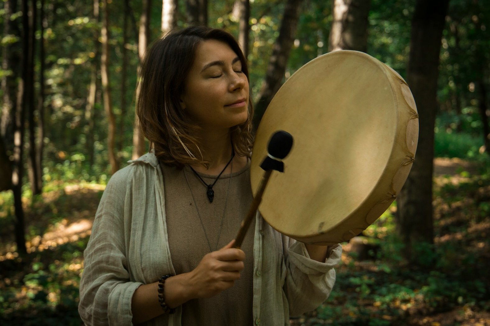 woman in gray sweater holding round brown hat