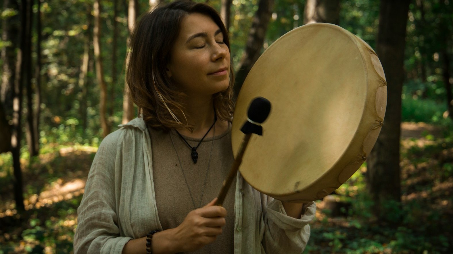 woman in gray sweater holding round brown hat