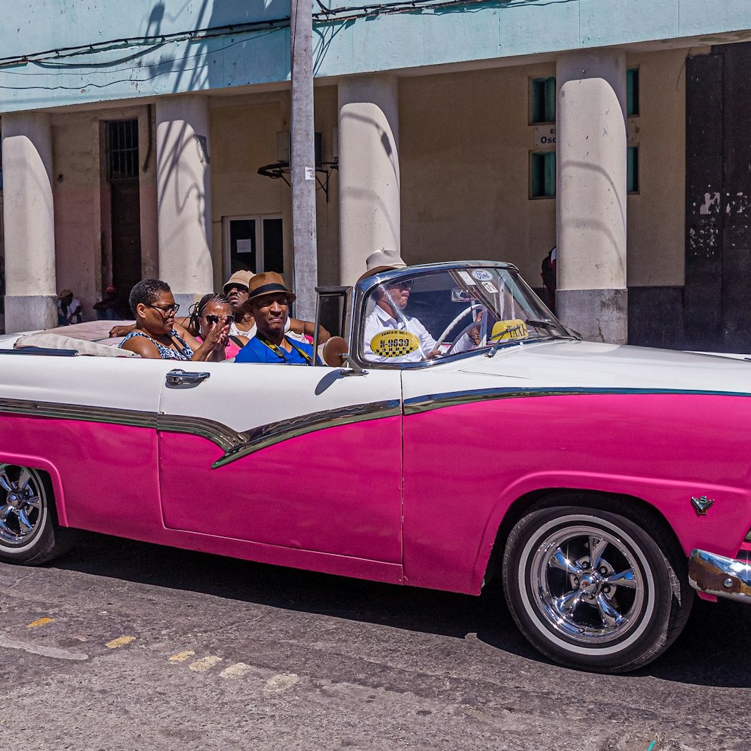 people in pink and white convertible coupe