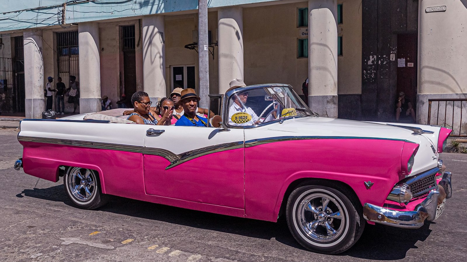 people in pink and white convertible coupe