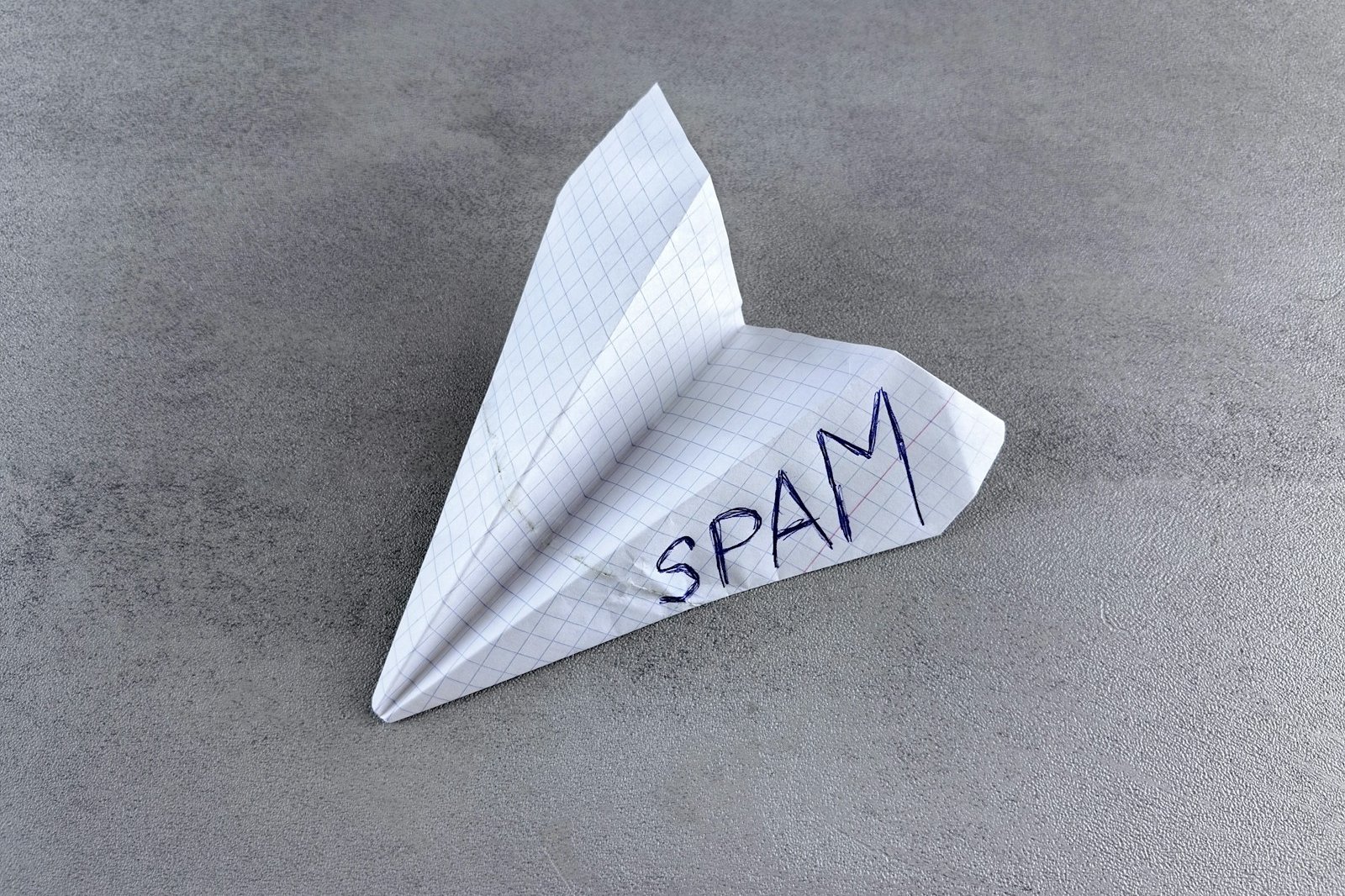 a paper airplane with the word spam written on it