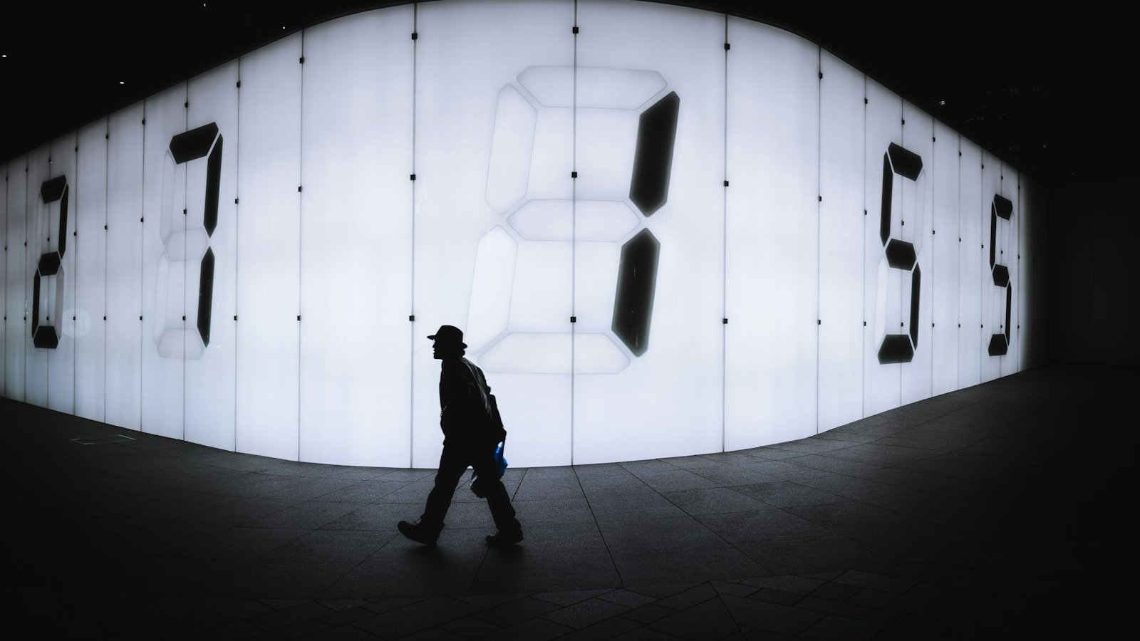 photo of man walking near LED signage